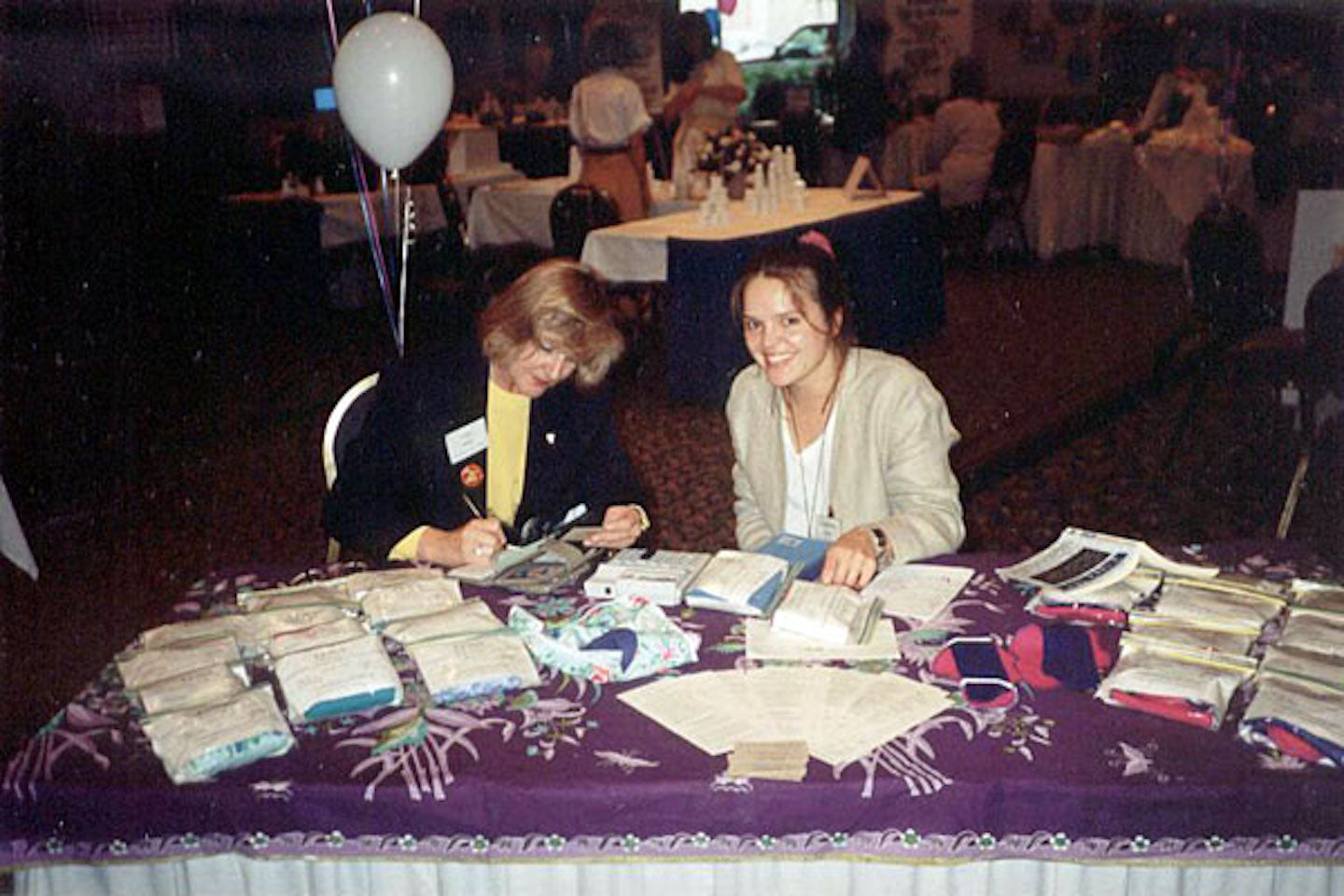 A photo from 1993 - Madeleine sits at a table displaying Lunapads products at an event.