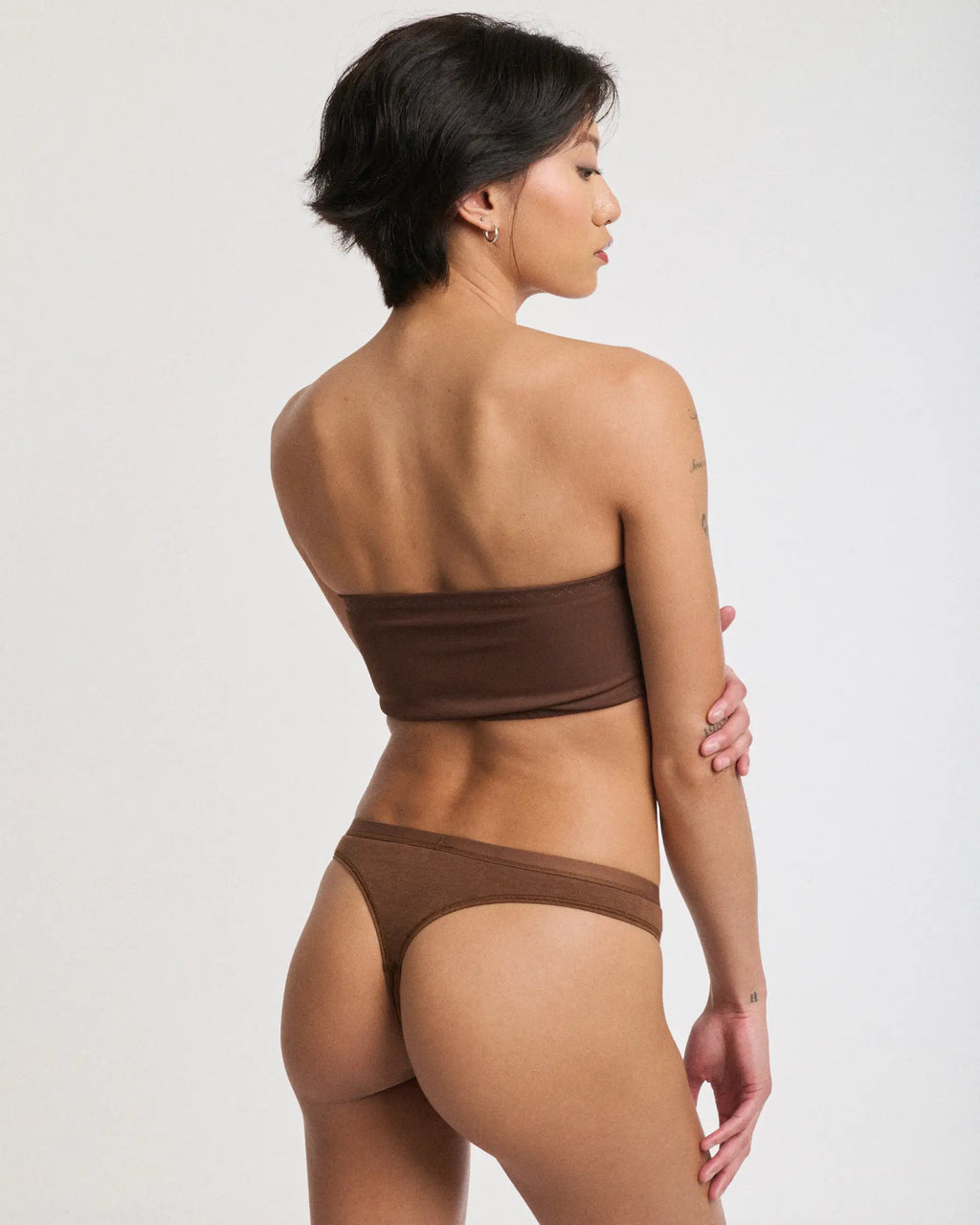 Rear view of a woman wearing brown thong-style period underwear | Espresso